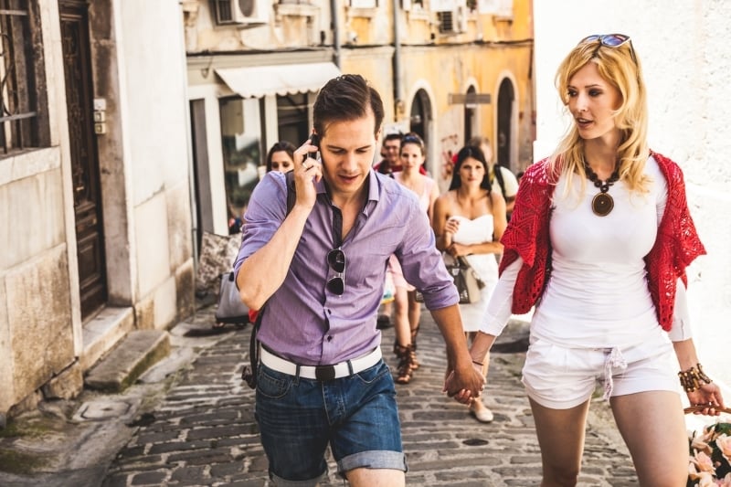 Couple using the phone while travelling