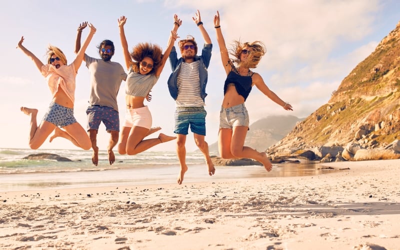 People jumping mid air on a beach