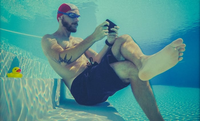 Man underwater using his mobile phone
